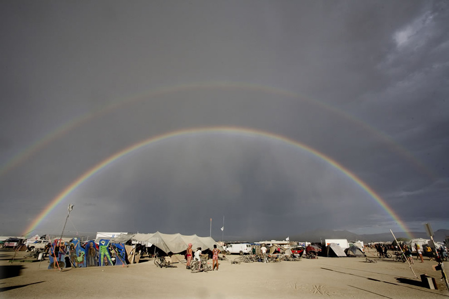 Double rainbow over Burning Man. You know about the pot of gold that Irish folklore says is at the end of a rainbow, but in Navajo and Hindu cultures, rainbows are interpretations of creation. In Australian Aborigines myths, the Rainbow Serpent is the god and the creator of all. Did you see The Avengers film? The Bifröst Rainbow Bridge connects Earth with Asgard, the home of the Norse mythology gods. The Greek messenger Iris was said to travel on a rainbow. Everybody and their dog has seen rainbows in all kinds of marketing. The real thing is pretty incredible to behold. Photo #8 by John curley