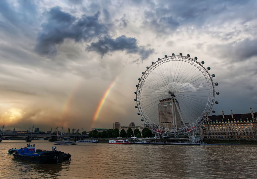 Double rainbow over the London Eye. Accuweather wrote, “Nature’s natural color spectrum always elicits the same pattern (red, orange, yellow, green, blue, indigo, violet) when light is refracted. While a primary rainbow is visible when light is reflected once off the back of a raindrop, a secondary and usually dimmer rainbow is spotted when light is reflected twice in a more complicated pattern. The colors of the second rainbow are inverted, with blue on the outside and red moved to the inside. The second bow appears dimmer or cloudier because much more light is released from two reflections, and both bows cover a larger portion of the sky. It is rare and unlikely, but three or even four rainbows can be seen on occasion, but only if they are reflected off of the earthly objects.” Photo #10 by Trey Ratcliff