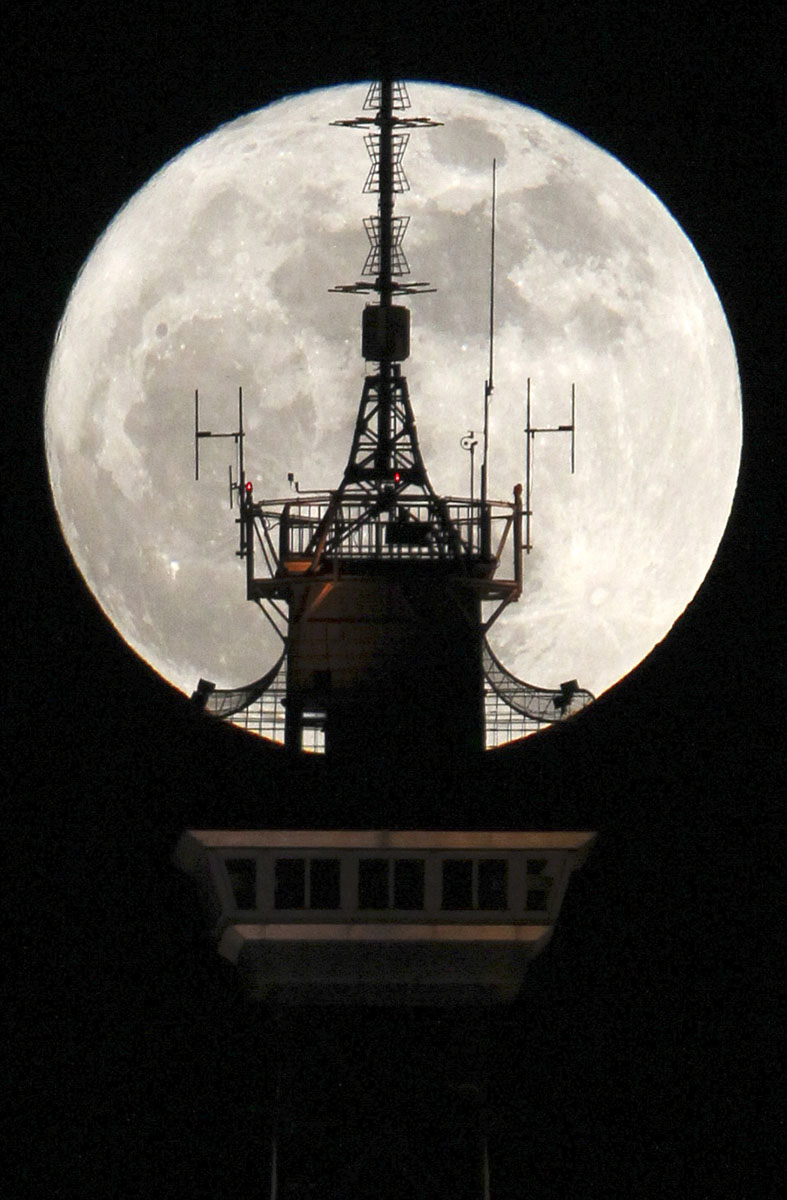 The moon is seen behind the top of the radio and television tower 'Funkturm' in Berlin